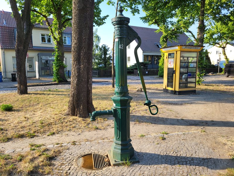 Wasserpumpe und alte Telefonzelle als Bücherbox Wasserpumpe und alte Telefonzelle als Bücherbox
